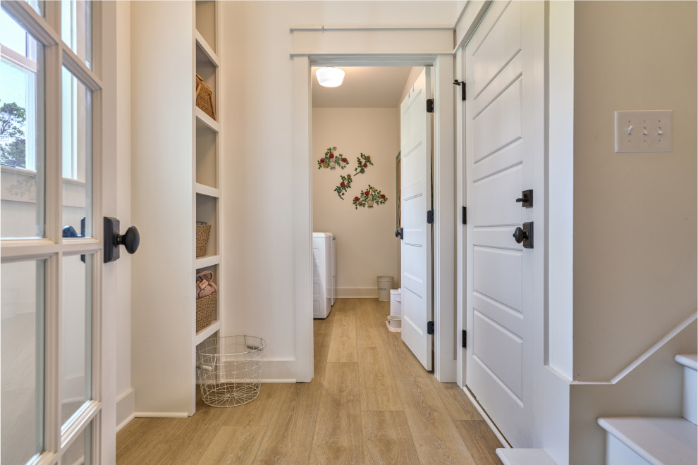 Mid-sized traditional hallway in Charlotte with white walls, vinyl floors, beige floor, vaulted and wallpaper.
