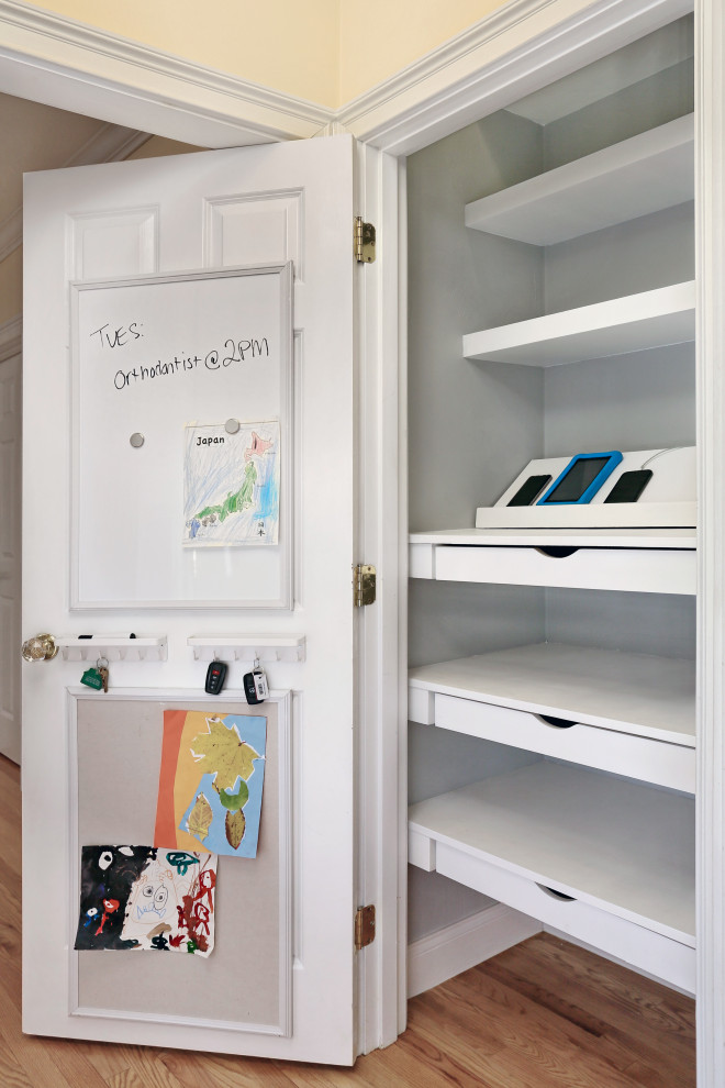 This is an example of a small transitional gender-neutral built-in wardrobe in Boston with open cabinets, white cabinets and medium hardwood floors.