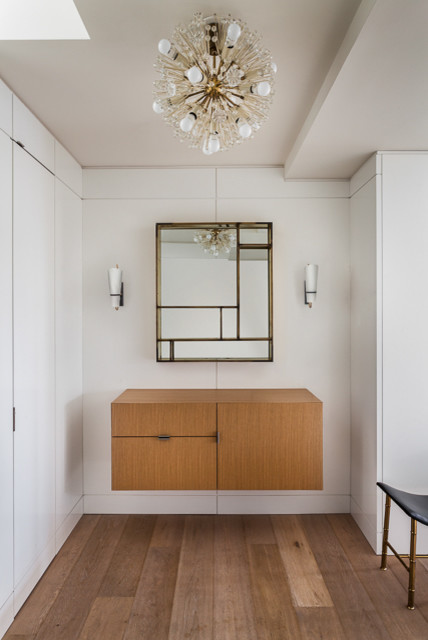Photo of a small midcentury foyer in New York with light hardwood floors and white walls.
