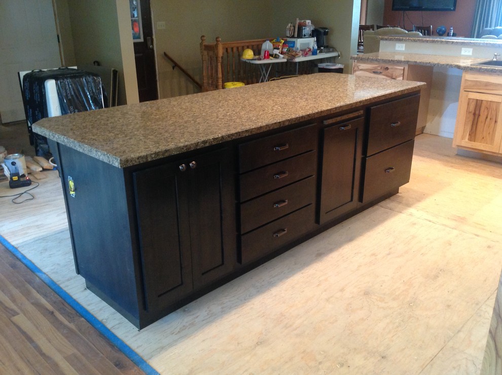 Open concept kitchen - mid-sized l-shaped open concept kitchen idea with raised-panel cabinets, light wood cabinets, laminate countertops, black appliances and a peninsula