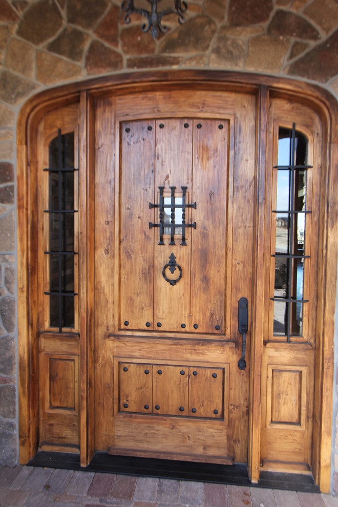 Example of a large mountain style front door design in Denver with a medium wood front door and beige walls