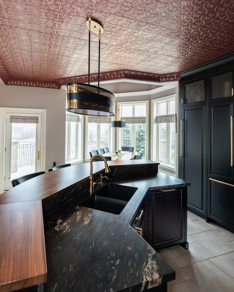 Example of a large eclectic kitchen design with raised-panel cabinets, black cabinets, granite countertops, black backsplash, granite backsplash, paneled appliances, an island and black countertops