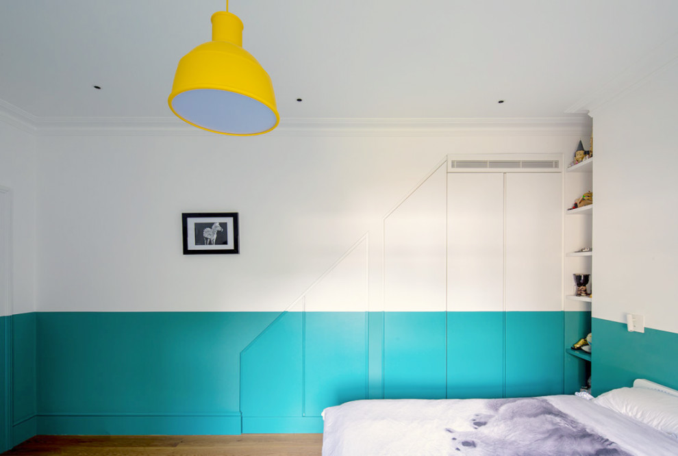 Imagen de dormitorio infantil de 4 a 10 años actual grande con paredes azules y suelo de madera clara