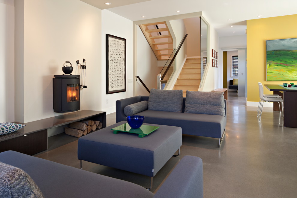 Mid-sized contemporary open concept living room in Calgary with a wood stove, multi-coloured walls, concrete floors, a metal fireplace surround, no tv and grey floor.