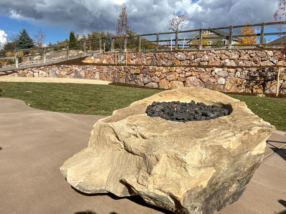 Inspiration for a large rustic sloped xeriscape full sun garden for spring in Denver with a fire feature, concrete paving and a wood fence.