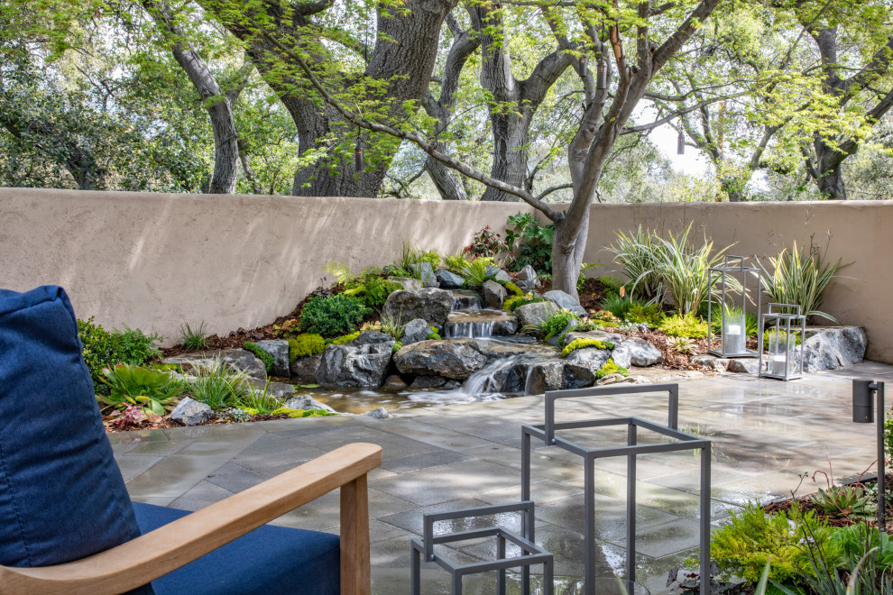 Small asian side yard partial sun formal garden in Los Angeles with with pond and concrete pavers for spring.