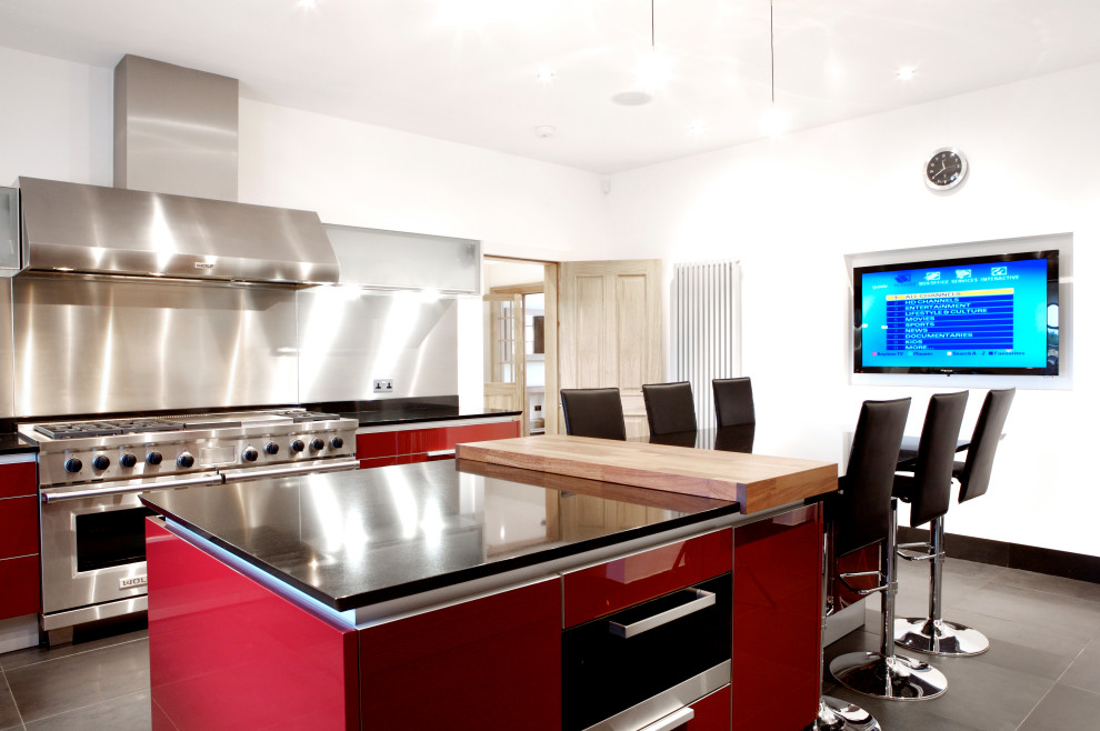 Large traditional u-shaped kitchen/diner in Edinburgh with red cabinets, marble worktops, metallic splashback, slate flooring, an island, grey floors and black worktops.