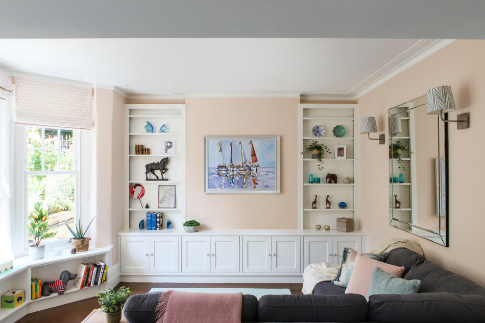 Mittelgroßes, Offenes Modernes Wohnzimmer mit rosa Wandfarbe, dunklem Holzboden, verstecktem TV und braunem Boden in London