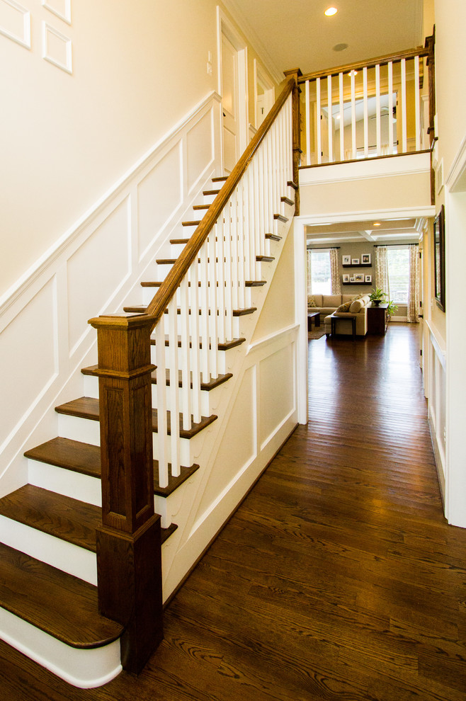 Inspiration for a mid-sized traditional wood straight staircase in Philadelphia with painted wood risers and wood railing.