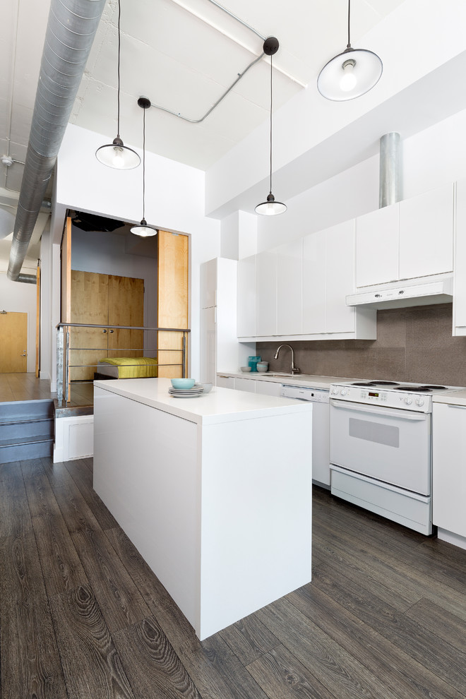 This is an example of an industrial single-wall open plan kitchen in Toronto with a single-bowl sink, flat-panel cabinets, white cabinets, quartz benchtops, grey splashback, stone tile splashback, white appliances, dark hardwood floors and with island.
