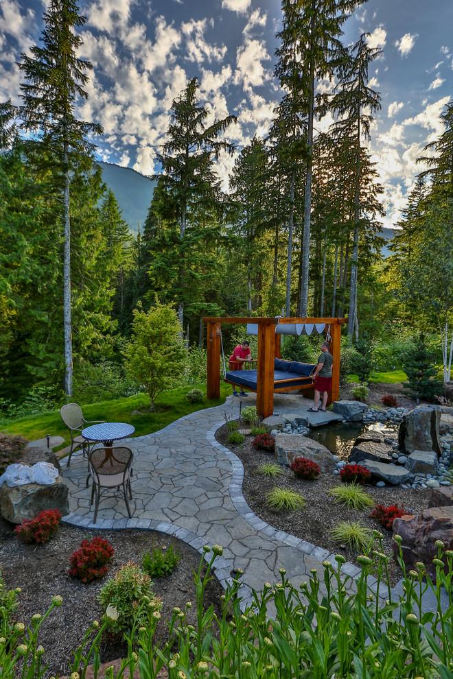 Design ideas for a large arts and crafts backyard patio in Seattle with a water feature, natural stone pavers and a gazebo/cabana.