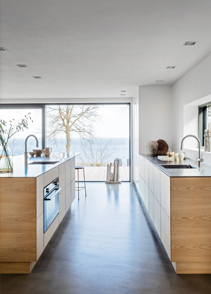 Mid-sized danish galley concrete floor and gray floor open concept kitchen photo in Copenhagen with an undermount sink, flat-panel cabinets, quartzite countertops, an island and gray countertops