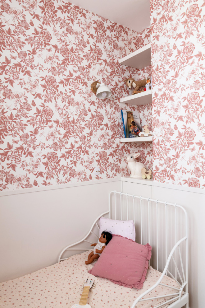 Cette image montre une petite chambre d'enfant de 1 à 3 ans nordique avec un mur rose, parquet clair et un sol marron.