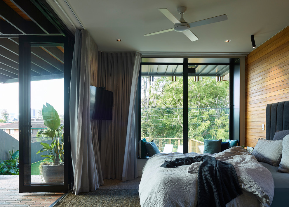 This is an example of a contemporary bedroom in Brisbane with brown walls, carpet and brown floor.