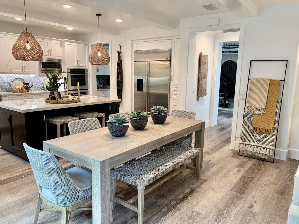 Design ideas for a mid-sized tropical u-shaped open plan kitchen in Orange County with an undermount sink, shaker cabinets, white cabinets, quartzite benchtops, grey splashback, cement tile splashback, light hardwood floors, with island, beige floor and grey benchtop.
