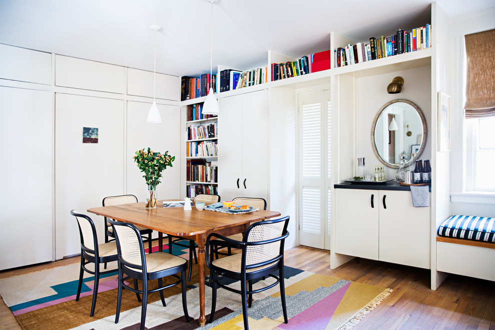 Photo of a beach style open plan dining in Boston with white walls, medium hardwood floors and no fireplace.