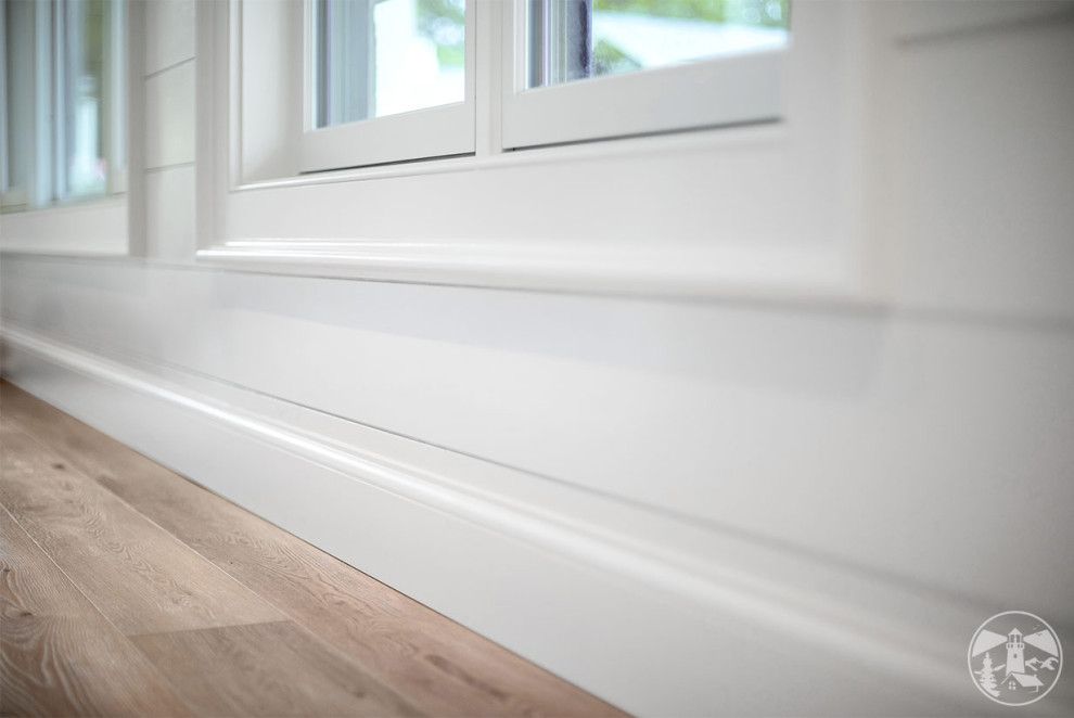 Small beach style vinyl floor, beige floor and shiplap wall hallway photo in Boston with white walls