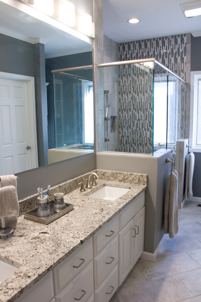 Inspiration for a mid-sized transitional master gray tile and ceramic tile ceramic tile walk-in shower remodel with an undermount sink, raised-panel cabinets, white cabinets, granite countertops, a two-piece toilet and gray walls