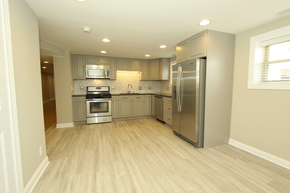 Small transitional l-shaped porcelain tile and gray floor kitchen photo in Chicago with an undermount sink, beaded inset cabinets, gray cabinets, quartz countertops, white backsplash, mosaic tile backsplash, stainless steel appliances, no island and gray countertops