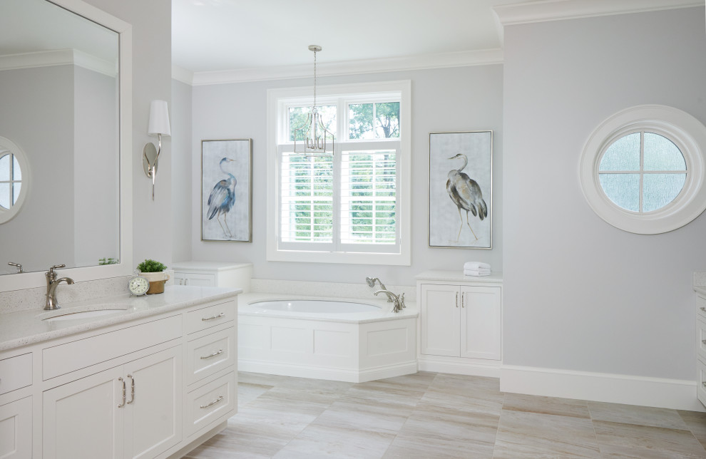 Inspiration for a large transitional master bathroom in Grand Rapids with white cabinets, an undermount tub, gray tile, grey walls, ceramic floors, an undermount sink, engineered quartz benchtops, beige floor, white benchtops, a double vanity, a built-in vanity and flat-panel cabinets.
