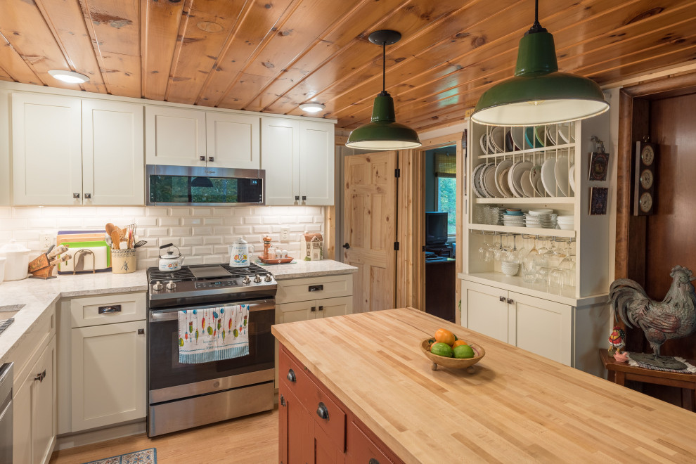 This is an example of a small eclectic l-shaped eat-in kitchen in Minneapolis with an undermount sink, shaker cabinets, white cabinets, quartz benchtops, white splashback, subway tile splashback, stainless steel appliances, laminate floors, with island, beige floor and beige benchtop.