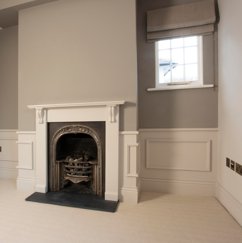 Large contemporary master bedroom in London with grey walls, carpet, a standard fireplace, beige floor, vaulted and a metal fireplace surround.