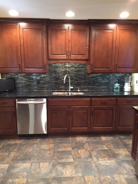 Inspiration for a transitional u-shaped porcelain tile enclosed kitchen remodel with an undermount sink, medium tone wood cabinets, granite countertops, black backsplash, mosaic tile backsplash, stainless steel appliances and no island
