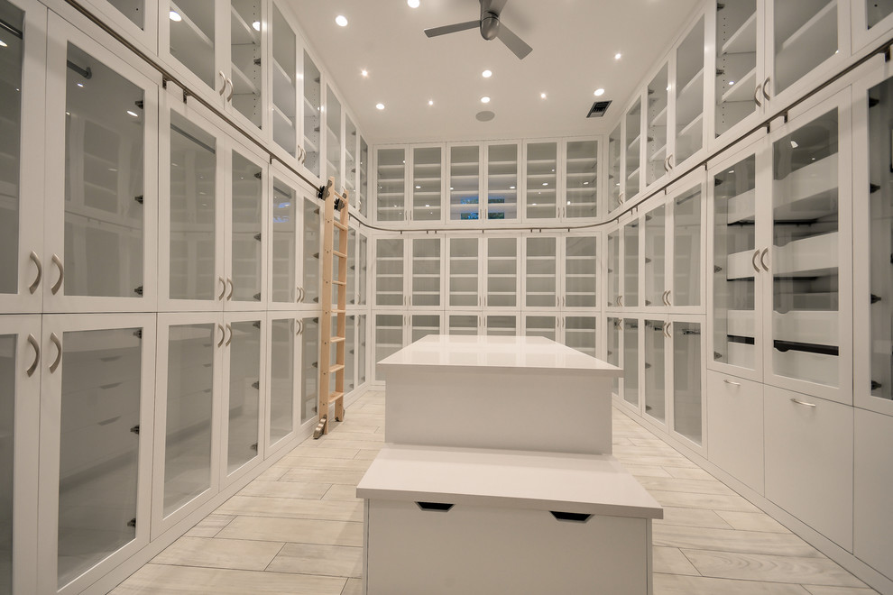 Design ideas for a large contemporary women's dressing room in Houston with glass-front cabinets, white cabinets and porcelain floors.