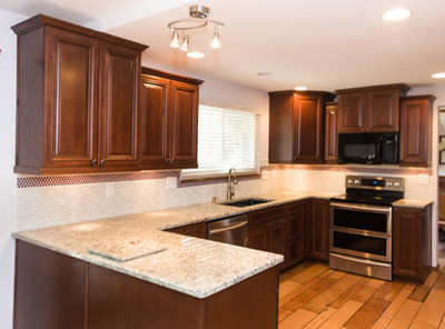 Example of a mid-sized transitional u-shaped light wood floor eat-in kitchen design in Denver with an undermount sink, raised-panel cabinets, medium tone wood cabinets, granite countertops, multicolored backsplash, mosaic tile backsplash, stainless steel appliances and a peninsula