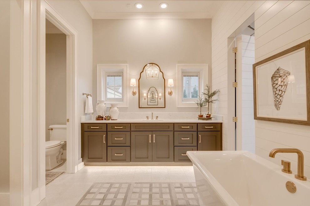 Photo of an expansive traditional master bathroom in Other with shaker cabinets, grey cabinets, a freestanding tub, a curbless shower, a two-piece toilet, gray tile, cement tile, grey walls, marble floors, an undermount sink, marble benchtops, grey floor and a hinged shower door.