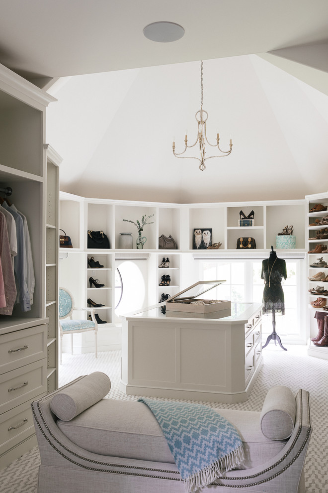 This is an example of a large transitional gender-neutral dressing room in Atlanta with open cabinets, white cabinets, carpet and beige floor.
