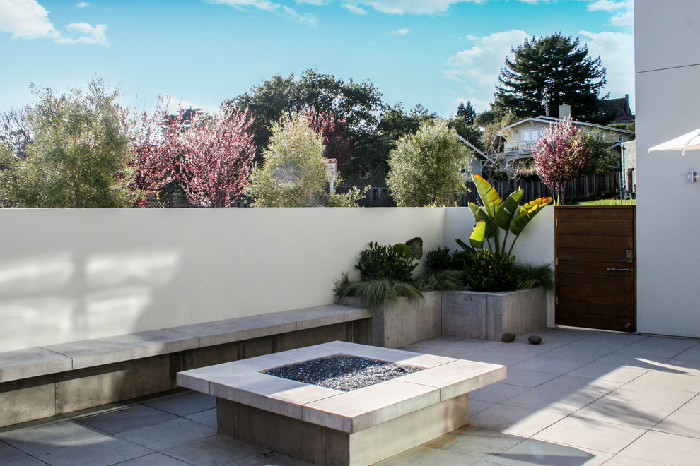 This is an example of a mid-sized contemporary backyard patio in San Francisco with concrete pavers and a roof extension.
