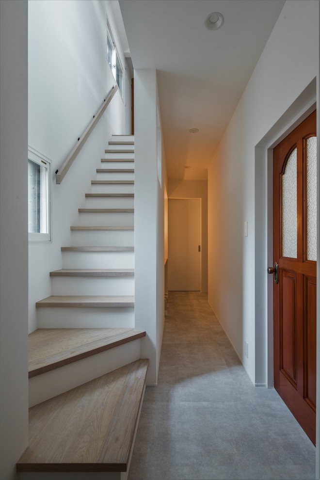 Small contemporary hallway in Other with white walls, light hardwood floors and grey floor.