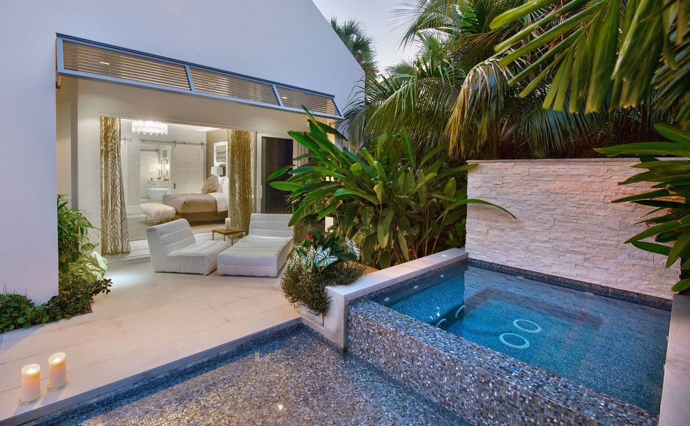 Photo of a beach style side yard pool in Miami with a hot tub.