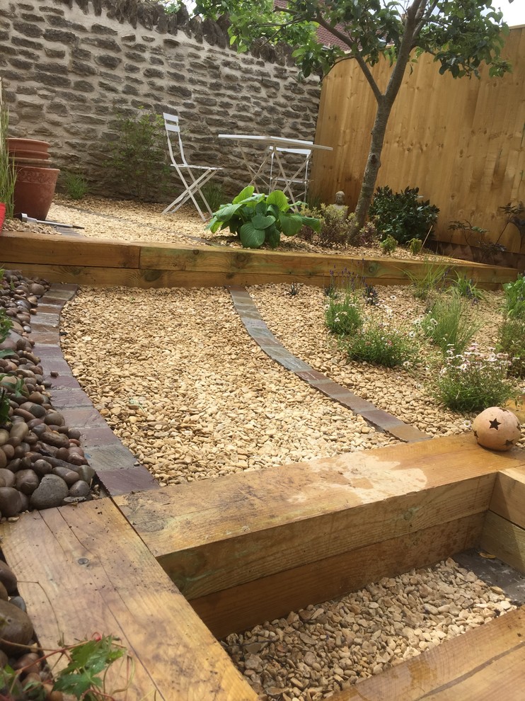 Photo of a small contemporary courtyard full sun garden for summer in Other with a retaining wall and gravel.