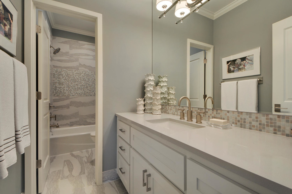 Example of a large transitional gray tile and mosaic tile porcelain tile alcove bathtub design in Austin with shaker cabinets, white cabinets, a one-piece toilet, gray walls, quartzite countertops and an undermount sink