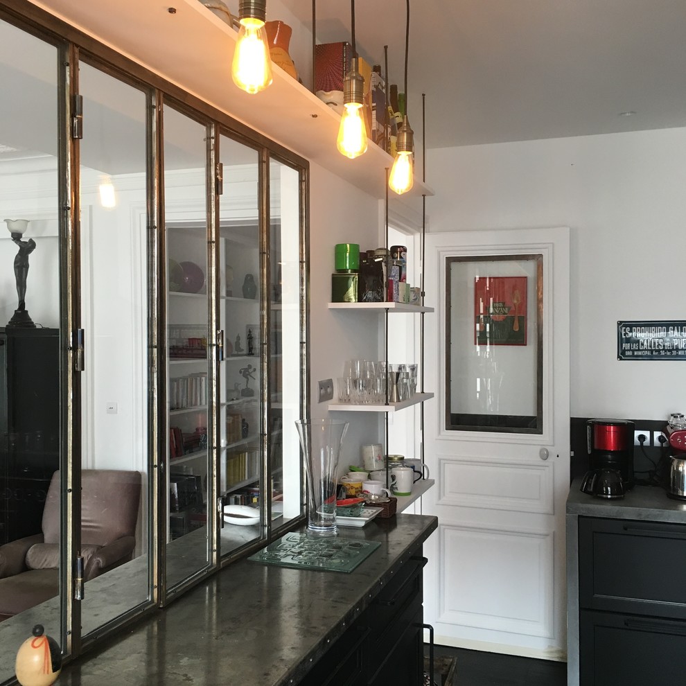 This is an example of a large industrial u-shaped separate kitchen in Paris with a double-bowl sink, beaded inset cabinets, black cabinets, concrete benchtops, black splashback, slate splashback, black appliances, slate floors, multiple islands, black floor and grey benchtop.