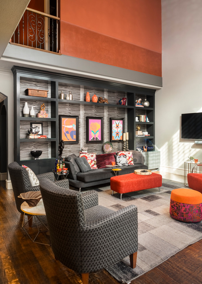 Inspiration for a mid-sized contemporary open concept family room in Dallas with a library, grey walls, medium hardwood floors, a standard fireplace, a tile fireplace surround, a wall-mounted tv and brown floor.
