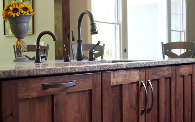 Transitional dark wood floor kitchen photo in Grand Rapids with white cabinets, granite countertops and an island