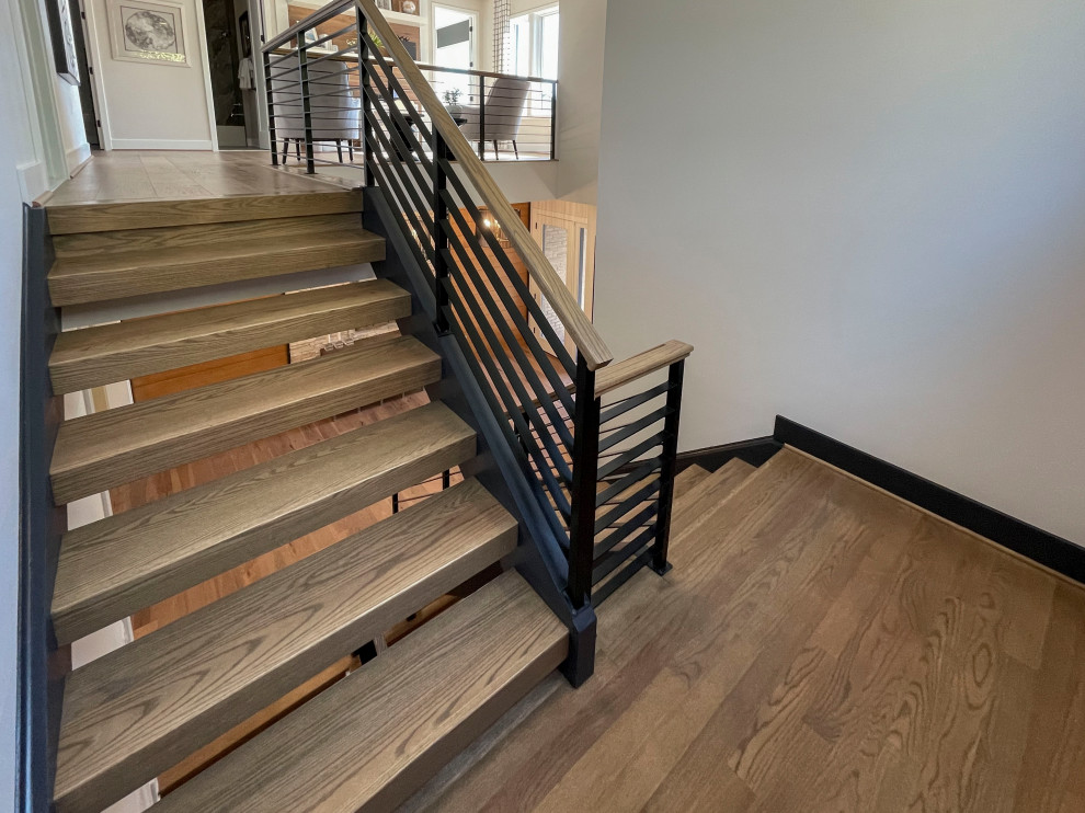 Design ideas for a large contemporary wood straight staircase in DC Metro with mixed railing and panelled walls.