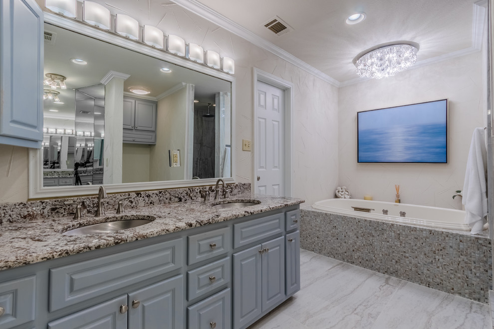Example of a mid-sized transitional master beige tile, gray tile and mosaic tile porcelain tile and gray floor drop-in bathtub design with raised-panel cabinets, gray cabinets, a one-piece toilet, beige walls, an undermount sink, granite countertops and a hinged shower door
