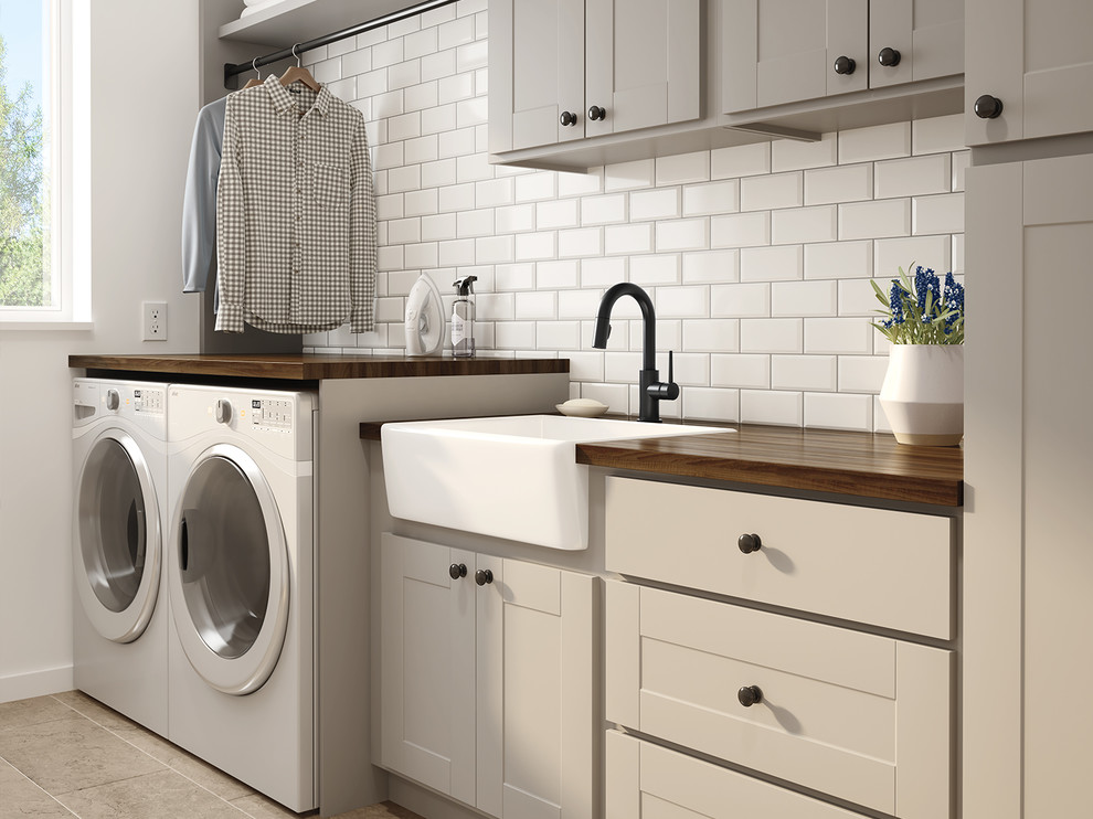 Inspiration for a transitional laundry room in Indianapolis with beige cabinets, wood benchtops, beige walls, travertine floors, a side-by-side washer and dryer and beige floor.