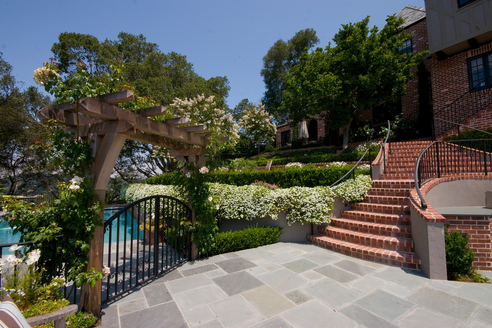 Photo of a traditional sloped garden in San Francisco with brick pavers.