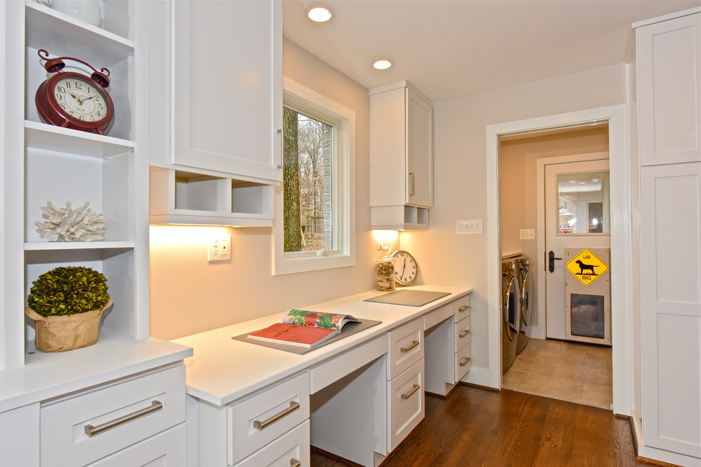 Photo of a large transitional utility room in DC Metro with an undermount sink, shaker cabinets, white cabinets, quartz benchtops, medium hardwood floors and a side-by-side washer and dryer.