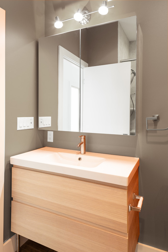 Inspiration for a mid-sized modern powder room in Detroit with flat-panel cabinets, brown cabinets, ceramic floors, an integrated sink, engineered quartz benchtops, brown floor and white benchtops.