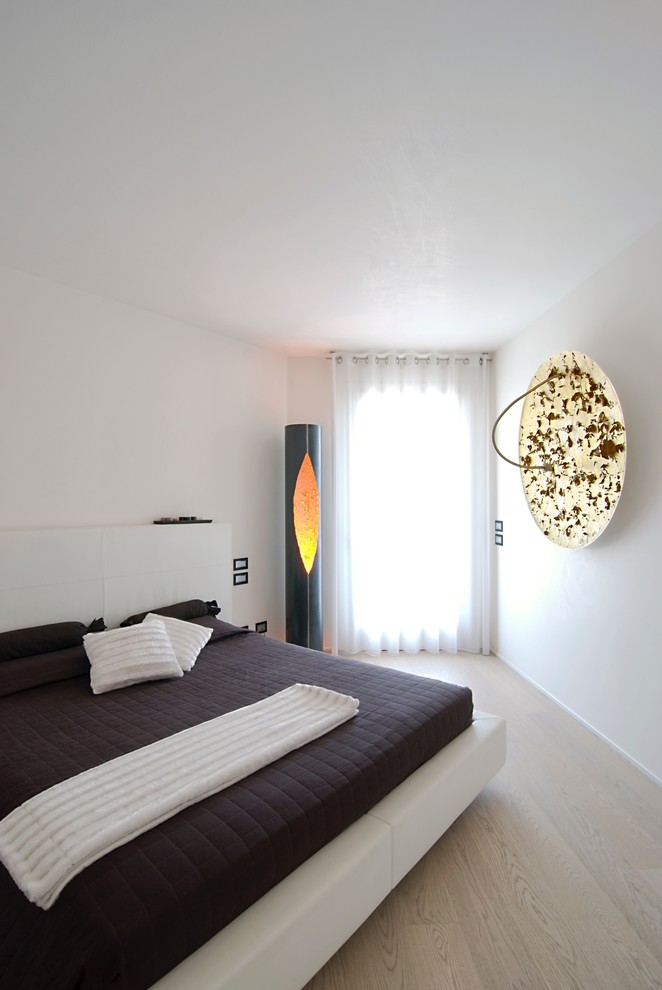 Inspiration for a contemporary bedroom in Venice with white walls, light hardwood floors and no fireplace.