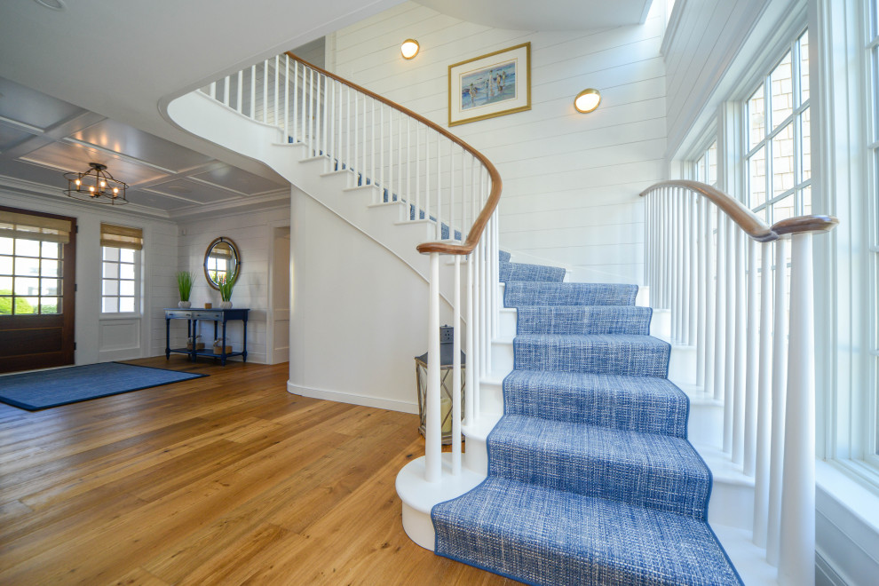 This is an example of a large traditional foyer in Philadelphia with white walls, light hardwood floors, a double front door, a dark wood front door, multi-coloured floor, coffered and planked wall panelling.