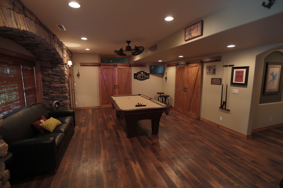 Large country basement in Milwaukee with brown floor, beige walls and dark hardwood floors.