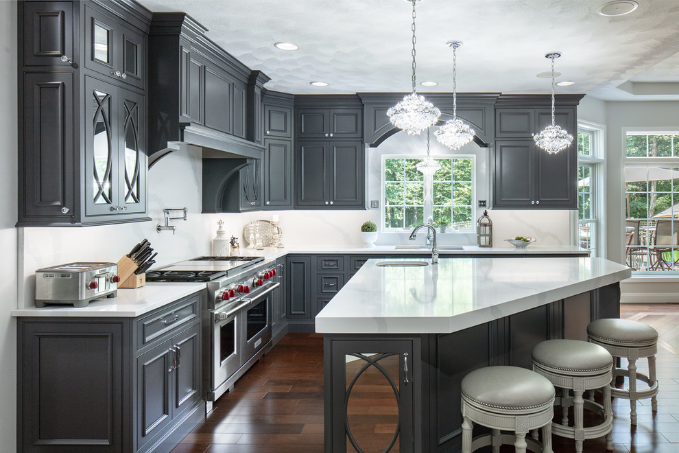 Photo of a large traditional l-shaped kitchen in Boston with an undermount sink, beaded inset cabinets, grey cabinets, quartz benchtops, stainless steel appliances, dark hardwood floors, with island, white benchtop and white splashback.
