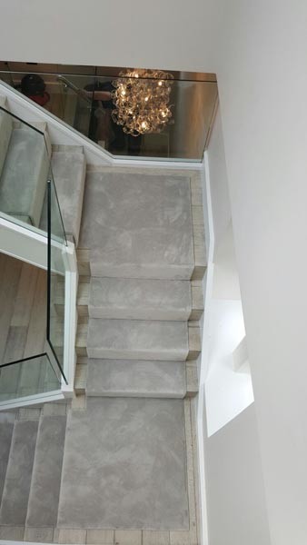 This is an example of a contemporary carpeted u-shaped staircase in London with glass railing.
